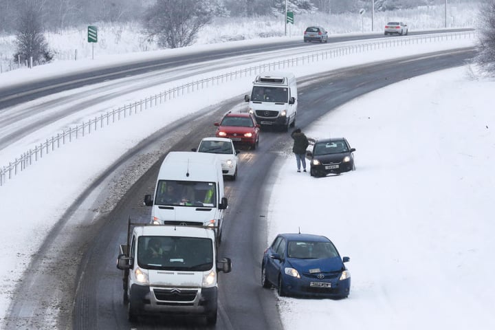 Autos stehen in Greenloaning (Großbritannien) auf der A9 am Straßenrand.