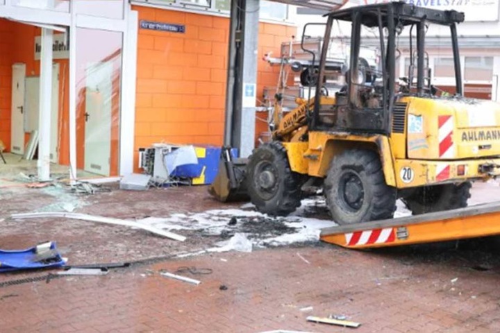 Der ausgebrannte Radlader steht vor dem Baumarkt. Vor ihm liegt noch der Geldautomat.