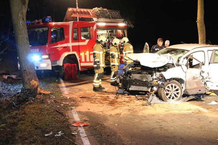 Die Einsatzkräfte stehen vor dem stark zerstörten Renault.