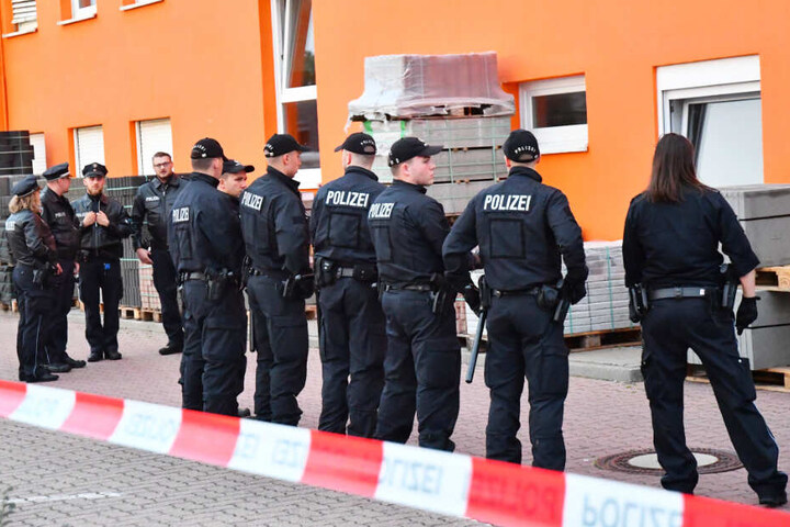 Zahlreiche Polizisten stehen vor dem Baumarkt.