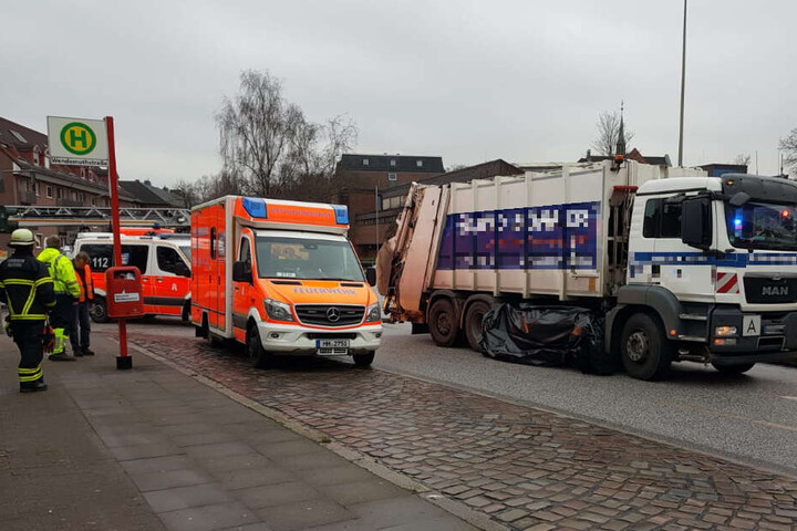 Helfer haben um den Müllwagen eine Plane als Sichtschutz gezogen.