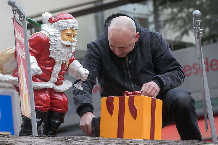 Ein Helfer befestigt an der Münzgasse letzte Deko-Geschenke. Der Markt startet morgen.