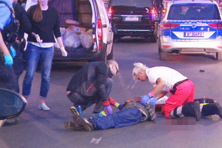 Sanitäter kümmern sich auf der Straße um den verletzten Mann.