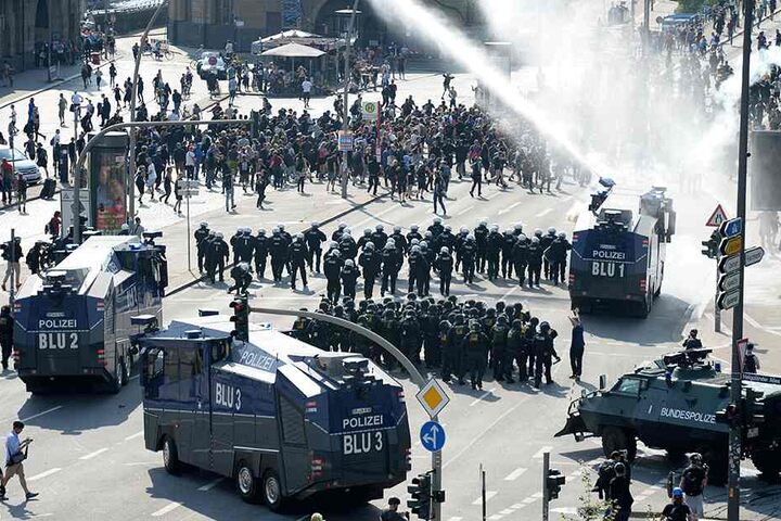 Nahe den Landungsbrücken setzen die Polizisten Wasserwerfer gegen Demonstranten ein.