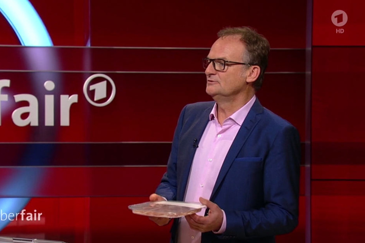 Frank Plasberg zeigt eine Verpackung: 130 Gramm Plastik für 70 Gramm Schinken...