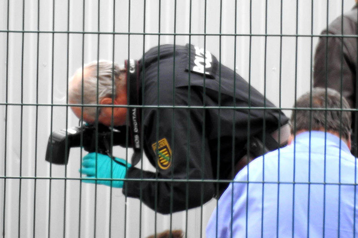Ein Kriminaltechniker fotografiert sichergestellte Schuhe und Bekleidung des Verdächtigen.