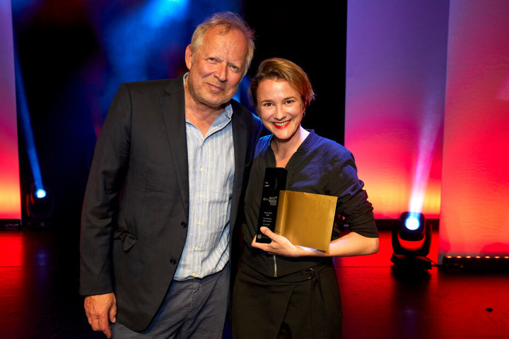 Axel Milberg, Schauspieler und Laudator, freut sich mit Eva Trobisch, Gewinnerin in der Kategorie "Bester Film", bei der Verleihung des Studio Hamburg Nachwuchspreises auf der Bühne des Thalia Theaters.