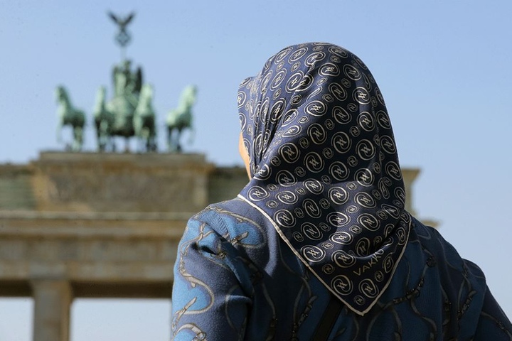 Eine Muslima mit Kopftuch vor dem Brandenburger Tor in Berlin.