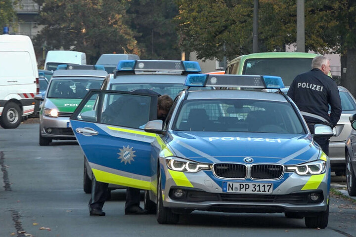 Polizeibeamte stehen an einem Streifenfahrzeug im Nürnberger Stadtteil Werderau.