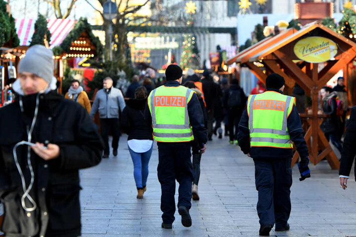 Zwei Polizisten laufen auf dem Weihnachtsmarkt am Breitscheidplatz Streife.