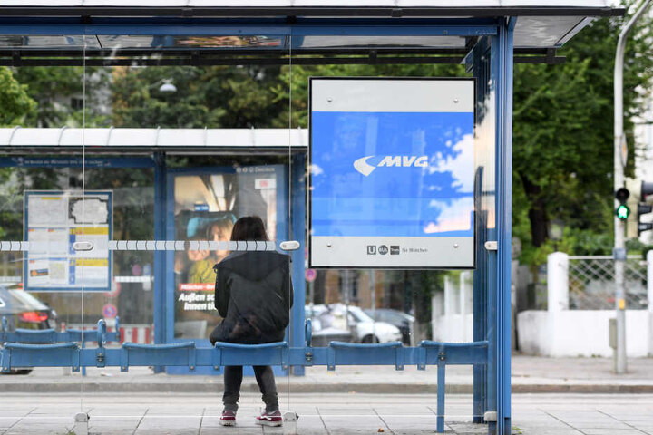 Eine Frau wartet an einer Straßenbahnhaltestelle. Bei der Münchner Verkehrsgesellschaft MVG gibt es seit den frühen Morgenstunden einen Warnstreik.
