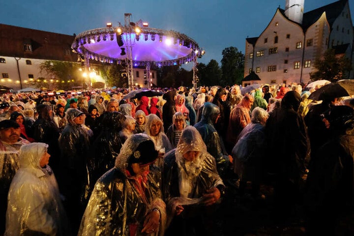 Besucher der MDR-Open-Air-Show "Die Schlager des Sommers" verlassen den Hof von Schloss Klaffenbach. Wegen eines heftigen Gewitters musste die Aufzeichnung unterbrochen werden.