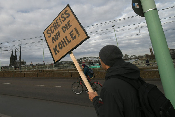 Ein Teilnehmer hält bei einer Demonstration von Umweltschützern «Kohle Stoppen - Klimaschutz jetzt» ein Schild hoch auf dem steht «Scheiss auf die Kohle!»