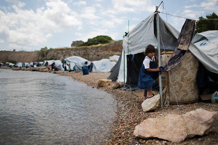 Ein Flüchtlingsmädchen aus Syrien geht am Strand von Chios (Griechenland) vor Zelten entlang. Die Zelte sind eine provisorische Unterkunft in der Nähe des Flüchtlingslagers Souda.
