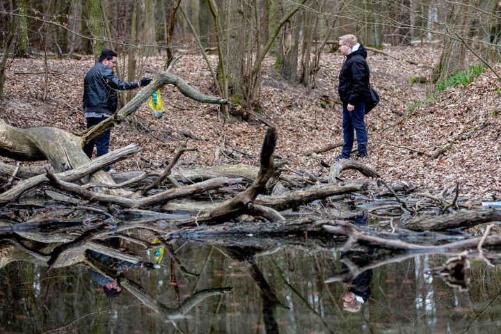 Daniel S. (l) und ein ehemaliger Mitschüler und Initiator der privat organisierten Suche nach Rebecca, Justin G., schauen an einem Teich in einem Waldstück in Hennigsdorf nach Hinweisen zur vermissten Rebecca.