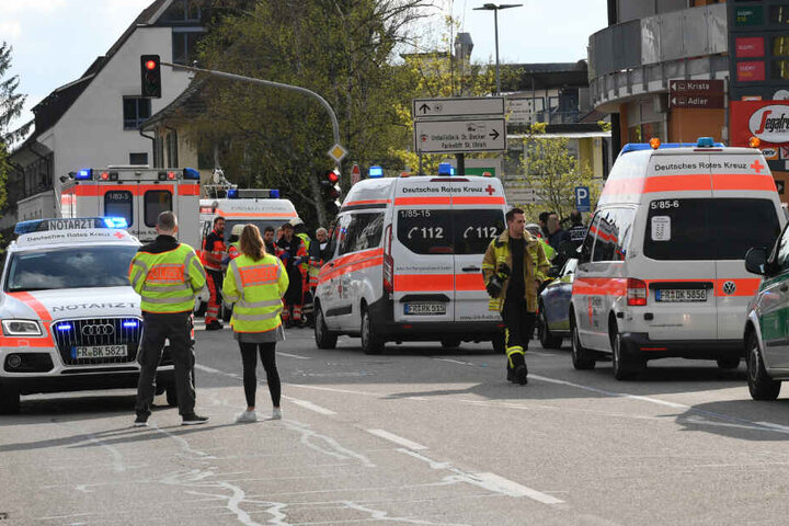 Rettungsfahrzeuge stehen an einer Kreuzung, an der ein Auto eine Familie erfasst hat.