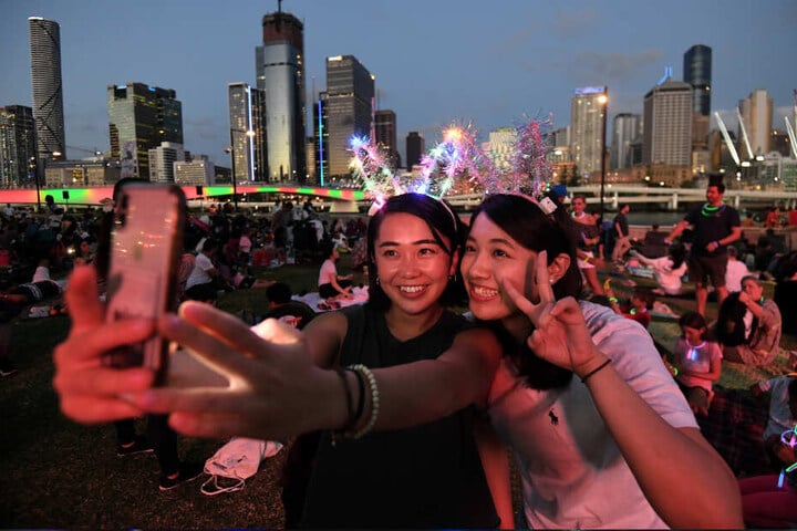 Brisbane: Mizuki (l) und Tsubasa machen ein Selfie, während sie auf den Start der Feuerwerksshow zum Jahreswechsel im Stadtteil South Bank warten.