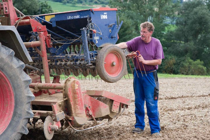 Landwirt Erhard Schröder steht an seiner Rotoregge, mit der das Martin Luther Bild kreiert hat.