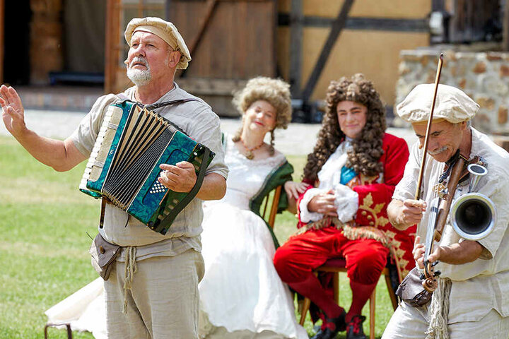 Der Hofschreiber (Peter Splitt, 2.v.r.) lässt die Musiker mit dem Publikum eine Hymne auf August den Starken singen.