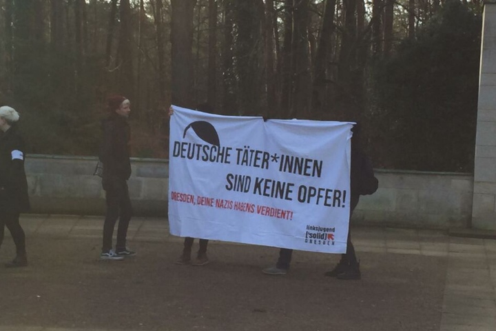 Einige Demonstranten haben sich vor dem Heidefriedhof versammelt.