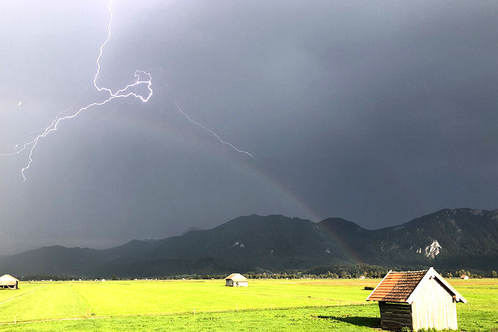 Gewitter und Blitze vor einem bayrischen Bergdorf.
