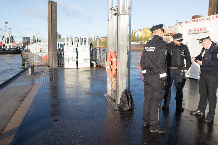Beamte stehen an einem Anleger an den Landungsbrücken: Hier wurde der Mann aus dem Wasser gezogen.