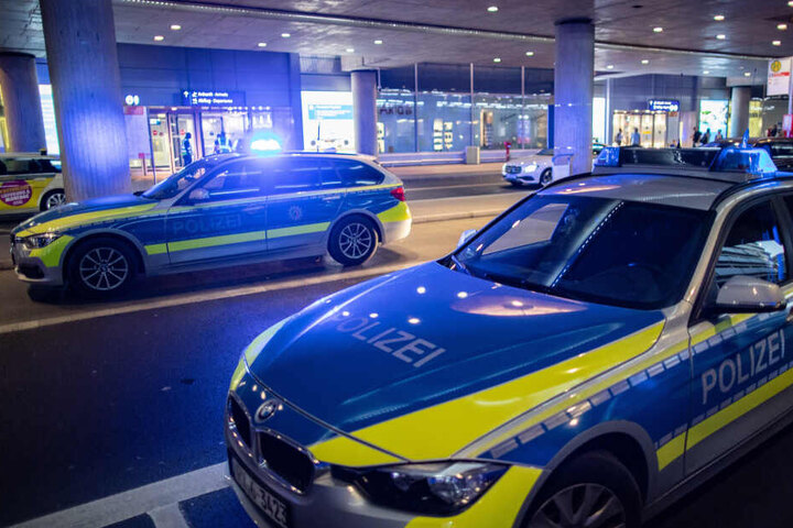 Streifenwagen der Polizei stehen vor dem Flughafengebäude