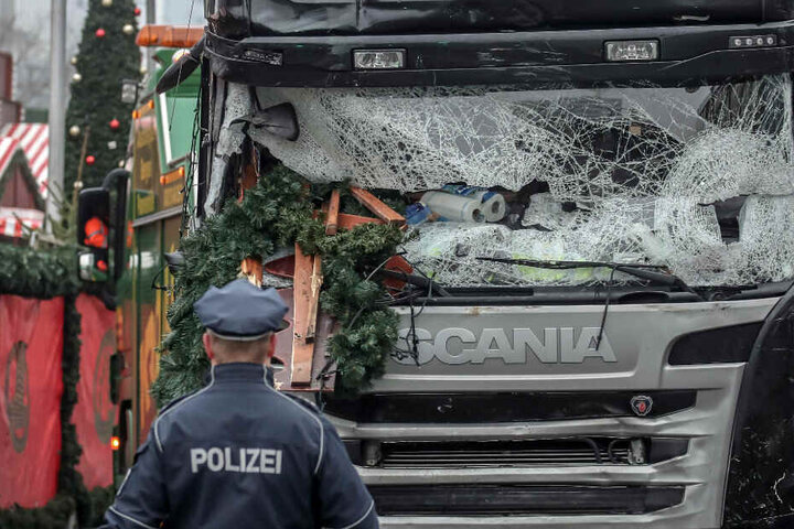 Ein Polizist steht vor dem Lastwagen, mit dem Attentäter Amri über den Weihnachtsmarkt gefahren ist.