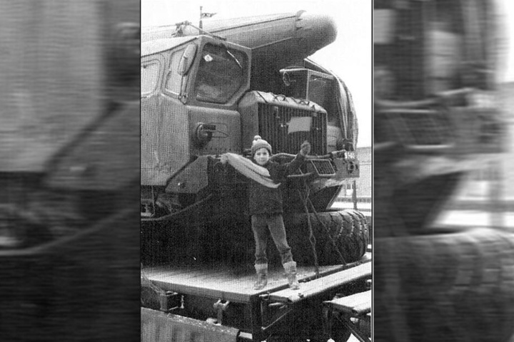Ein Kind vor einem beladenen Raketentransporter.