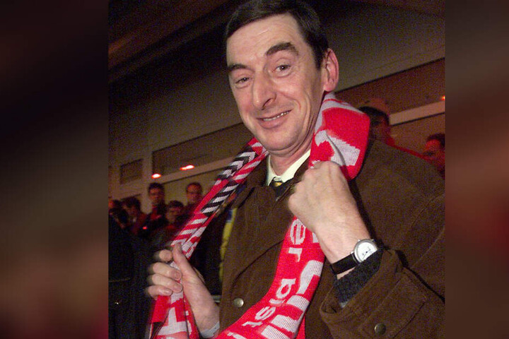Daniel Nivel hängt sich zu Beginn eines Fußballspiels des 1. FC Kaiserslautern gegen den RC Lens in Kaiserslautern einen Fanschal der Lauterer um. (Archivbild)