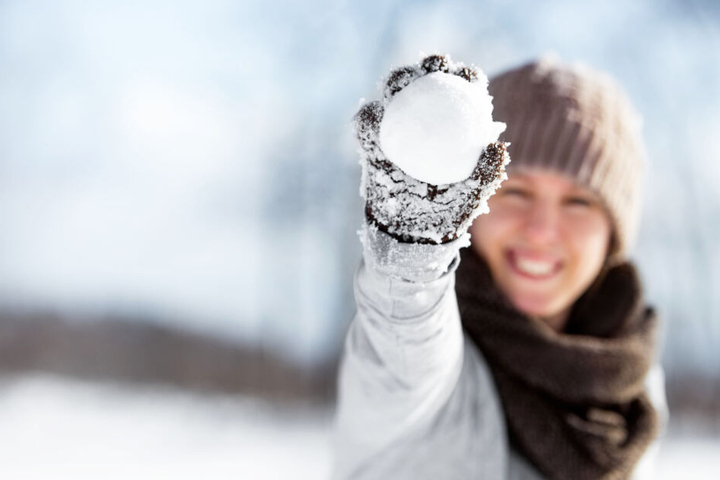 Eine Frau hält einen Schneeball (Symbolbild).