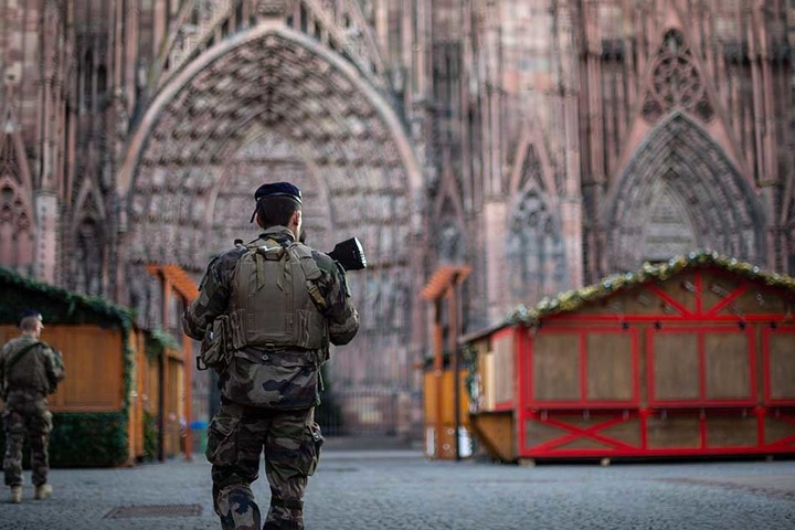 Ein bewaffneter Polizist patrouilliert auf dem Weihnachtsmarkt in Straßburg.