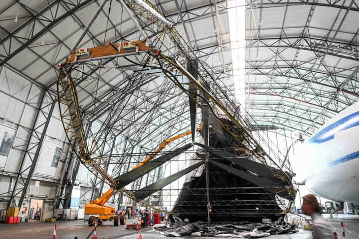 Besucher sehen sich den im Wiederaufbau befindlichen Zeppelin an.