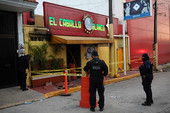 Polizeibeamte stehen vor der Bar "El caballo blanco" in Coatzacoalcos und sichern den Tatort.