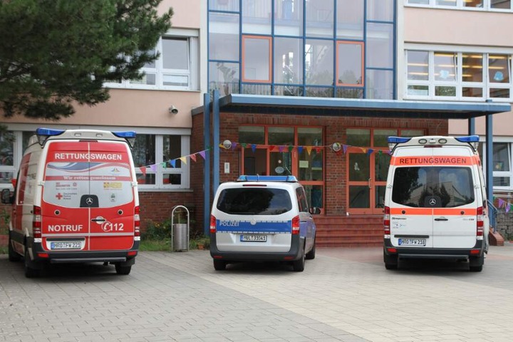 Polizei und Rettungsdienst stehen vor der dem Gebäude.
