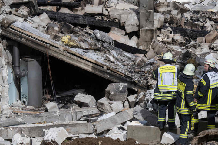 Feuerwehrleute stehen am 22.03.2019 vor den Trümmern des Wohnhauses.