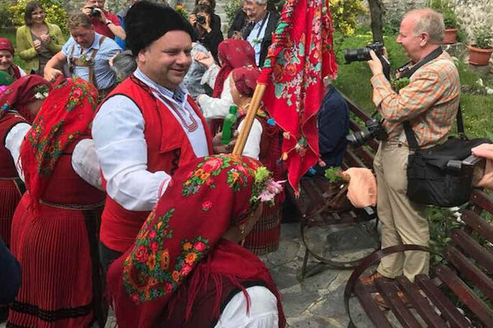 Zum Willkommen schwenken die Dorffrauen eine bunte "Fahne" und stimmen ein Volkslied an.