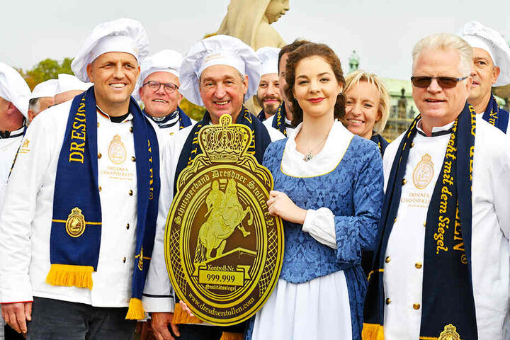 Die Dresdner Bäckermeister Rene Krause (43, l.), Reiner Israel (66, 2.v.l.) und Mühlenbäcker-Chef Volker Beduhn (61, r.) drängeln sich um ihr schönes Dresdner Stollenmädchen Veronika Weber (23).