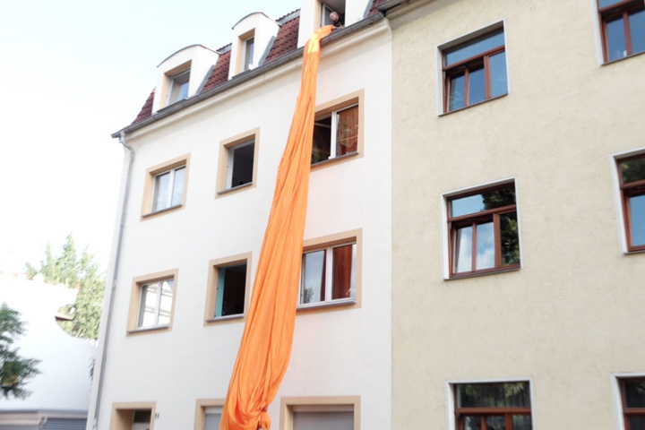 Hier wird die größte Blockfahne Europas aus einem Wohnhaus in Dresden herabgelassen.