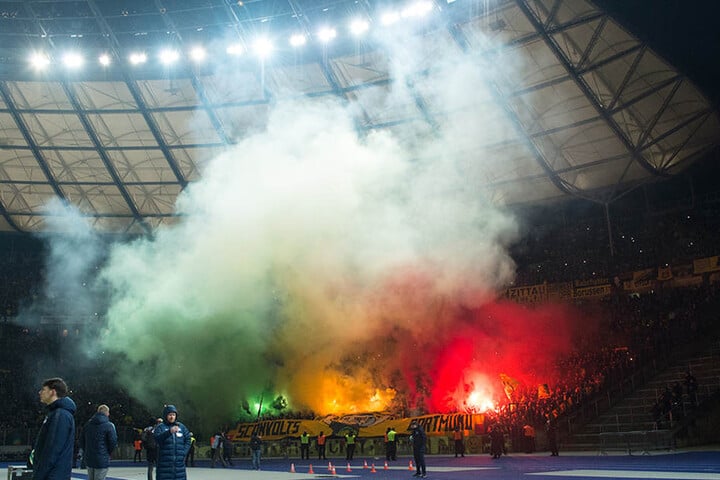 Im Gästeblock der Dortmunder werden kurz nach Anpfiff der zweiten Spielhälfte Leuchtfeuer gezündet.