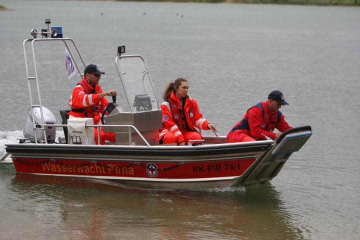 Ehrenamtler der Wasserwacht Pirna helfen der Polizei bei der Suche nach einer Frau am Kiessee Birkwitz.