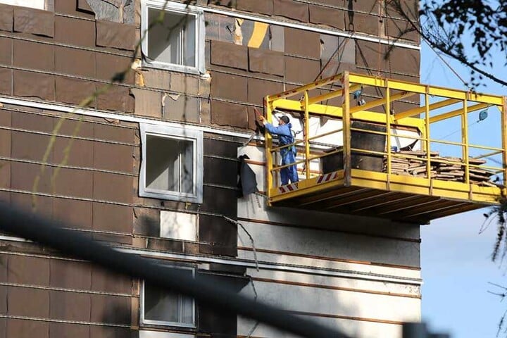 Ein Arbeiter ist damit beschäftigt, die Fassade des Hotels auf die Sprengung vorzubereiten.