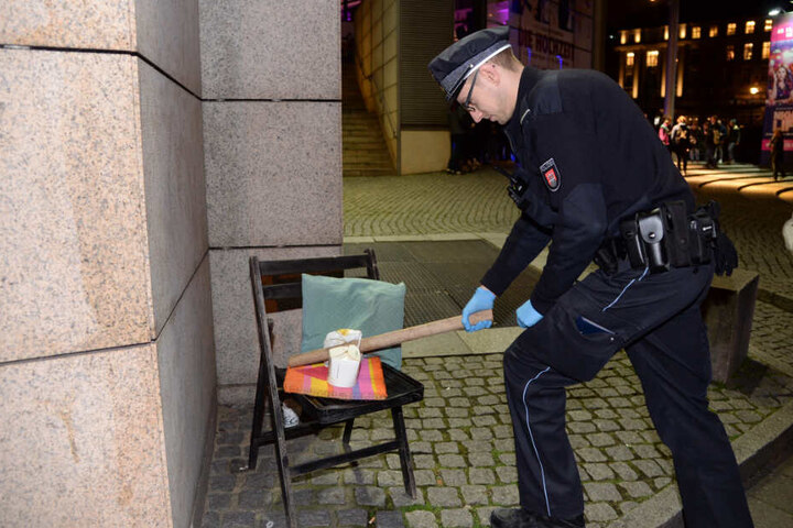 Ein Polizist sichert vor dem Kino das Stuhlbein.