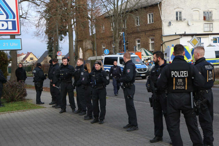 Ein Großaufgebot an Polizisten vor dem Parkplatz eines Supermarktes.