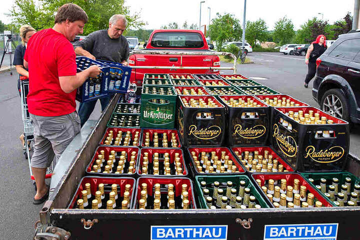 Bierkästen werden auf einen Anhänger geladen.