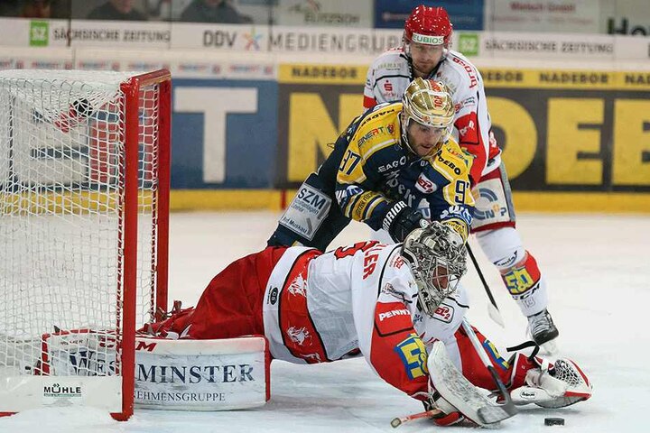 Dennis Swinnen (97, Lausitzer Fuechse) versucht sich gegen Goalie Ryan Nie (35, Crimmitschau) und Andre Schietzold (13, Crimmitschau) duchzusetzen.