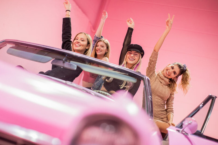 Models testen eine rosa Autokulisse in dem Museum.