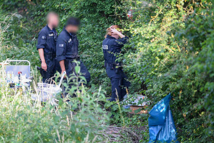 Polizisten untersuchen die Fundstelle der Leiche auf Spuren.