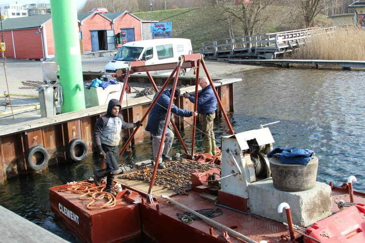 Mitarbeiter einer Rostocker Spezialfirma erweitern derzeit die Steganlage im Cospudener Hafen.