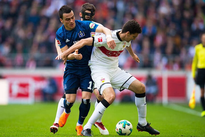 VfB-Innenverteidiger Marcin Kaminski (r.) im Zweikampf mit HSV-Flügelstürmer Filip Kostic (l.). Maskenmann Christian Gentner (hinten) greift unterstützend ein.